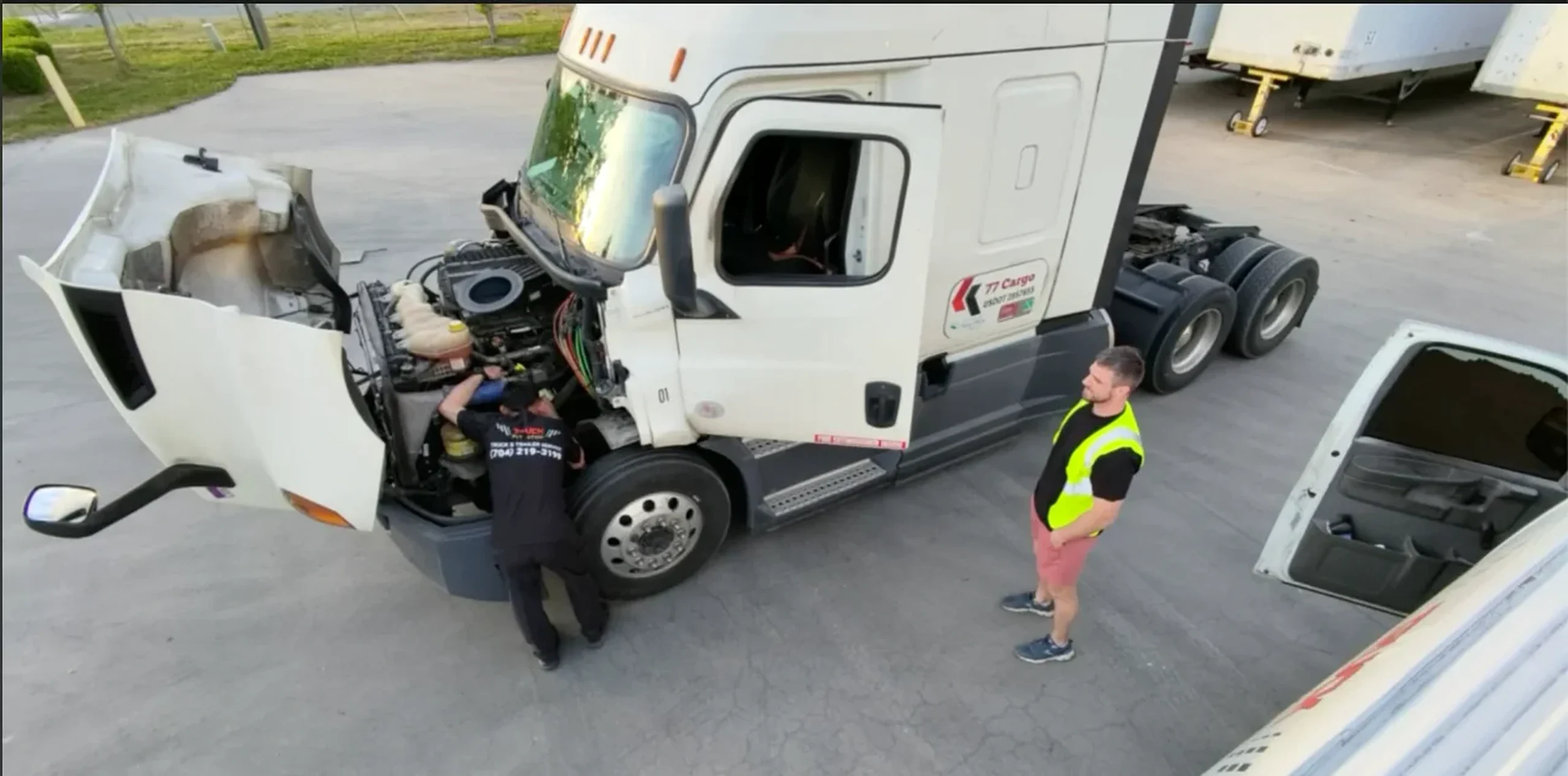 Semi-Truck Pre-Purchase Inspection in Charlotte: 4 Checks Before You Buy 1 Truck Pit Stop employees working under the hood of a white semi-truck