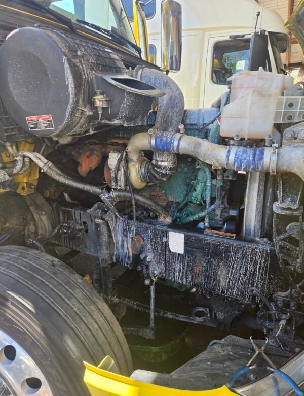 Open hood and Volvo D13 engine bay during coolant-system diagnosis