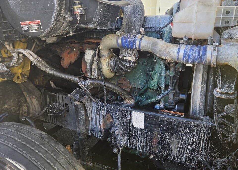 Open hood and Volvo D13 engine bay during coolant-system diagnosis