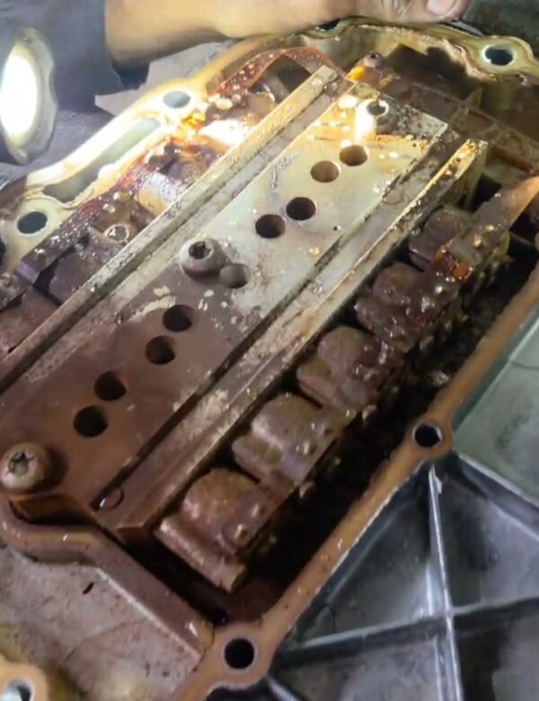 Mechanic inspecting an opened truck transmission control assembly during repair