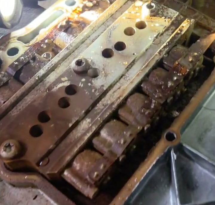 Mechanic inspecting an opened truck transmission control assembly during repair