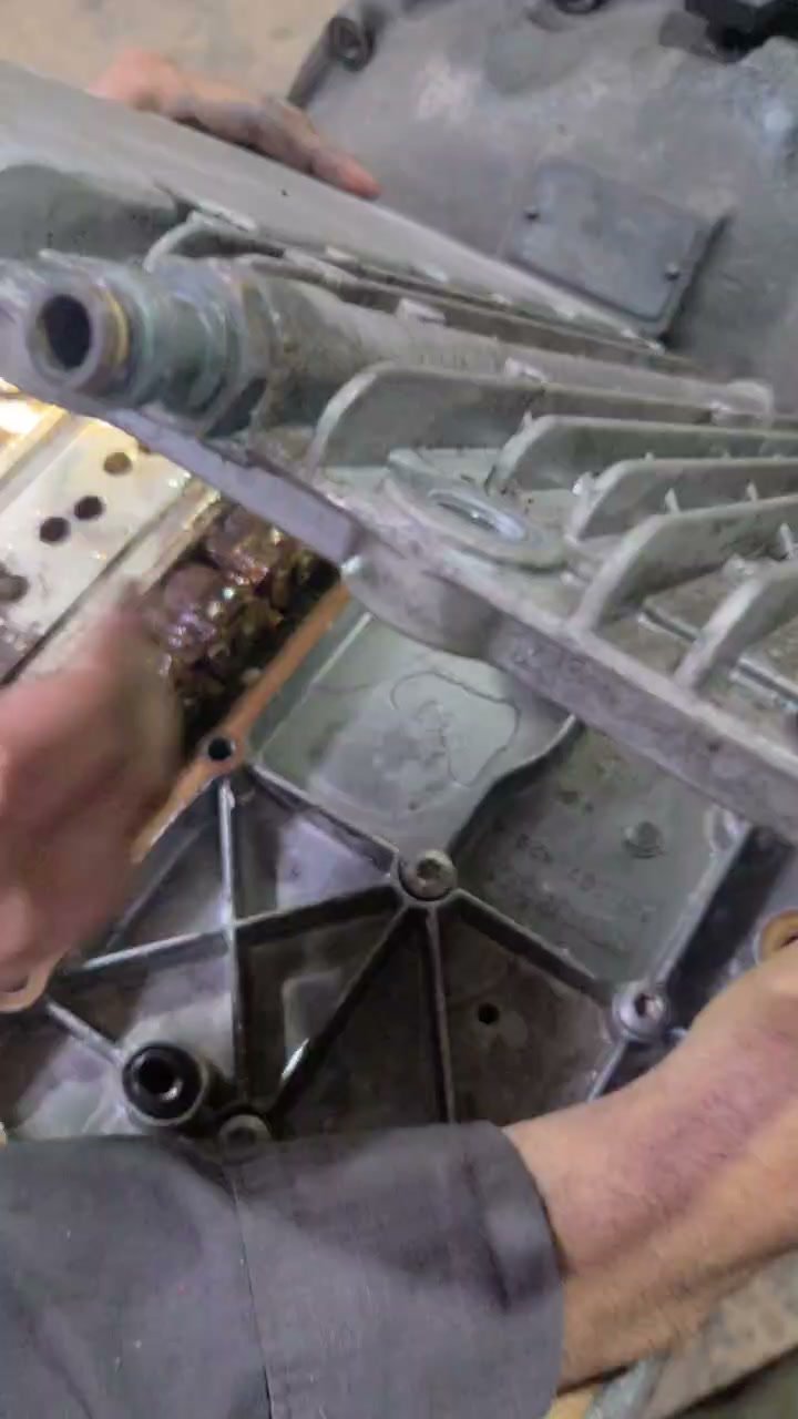 Mechanic handling a truck transmission component during repair