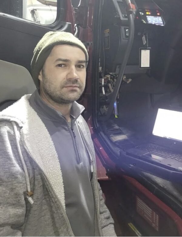 Truck Pit Stop mechanic with a diagnostic laptop plugged into a semi truck to read SPN and FMI fault codes in Matthews, North Carolina