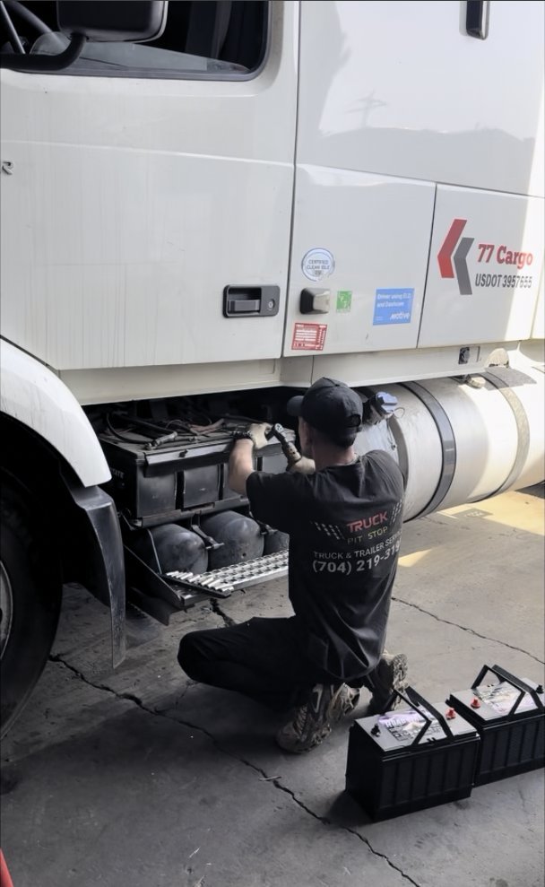 Truck Pit Stop mechanic replacing the batteries on a Volvo semi truck before winter in Matthews, North Carolina